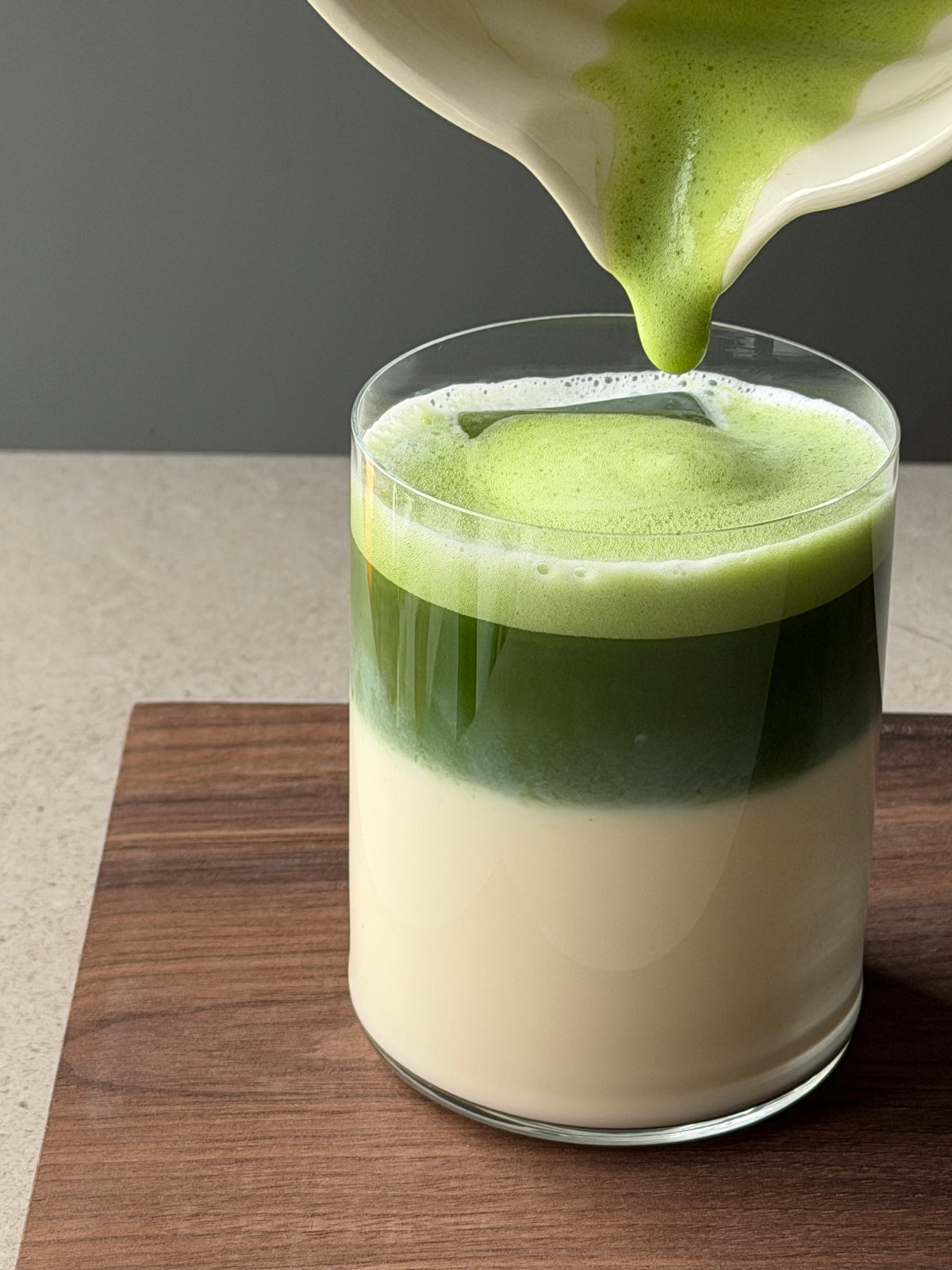 a green liquid being poured into a glass