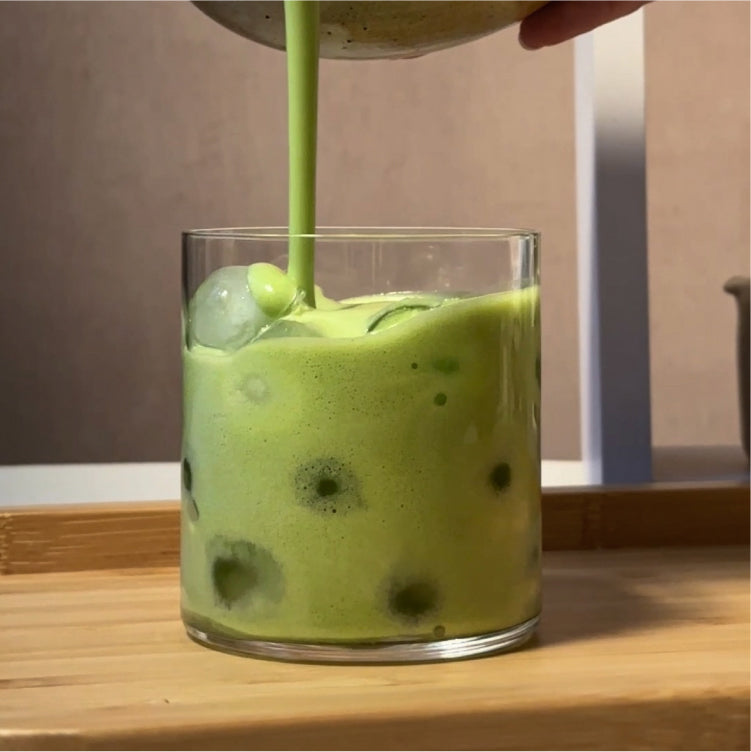 a green liquid being poured into a glass