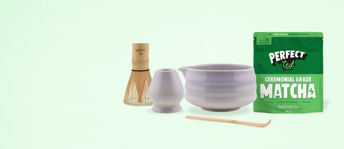 a white bowl and a white cup and a bamboo whisk