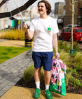 Max wearing a white graphic t-shirt smiling outside 