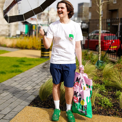 Max wearing a white graphic t-shirt smiling outside 