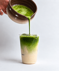 a person pouring green liquid into a glass