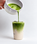 a person pouring green liquid into a glass